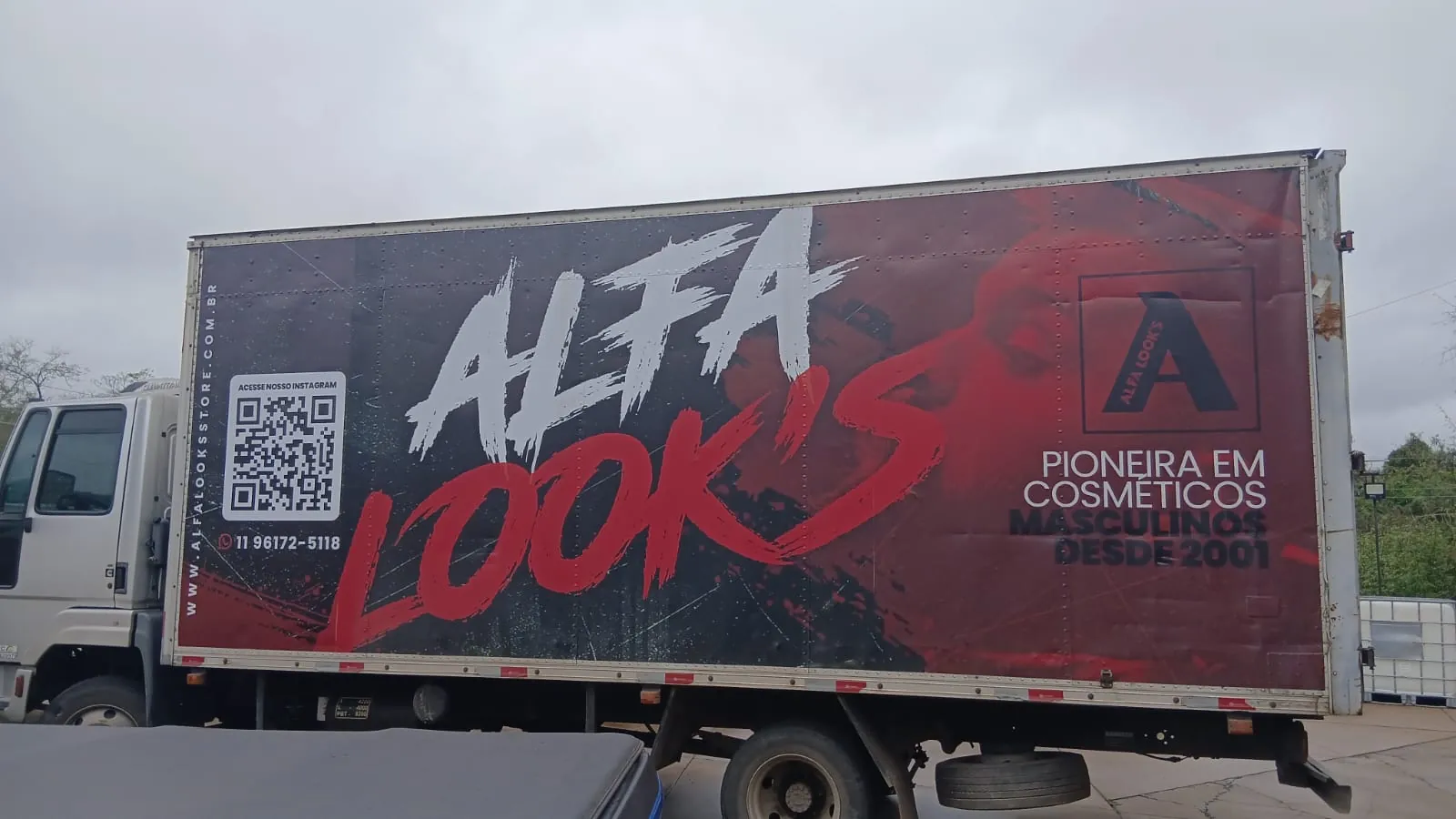 Baú de caminhão envelopado com a identidade visual da Alfa Look's, com QR Code e telefone