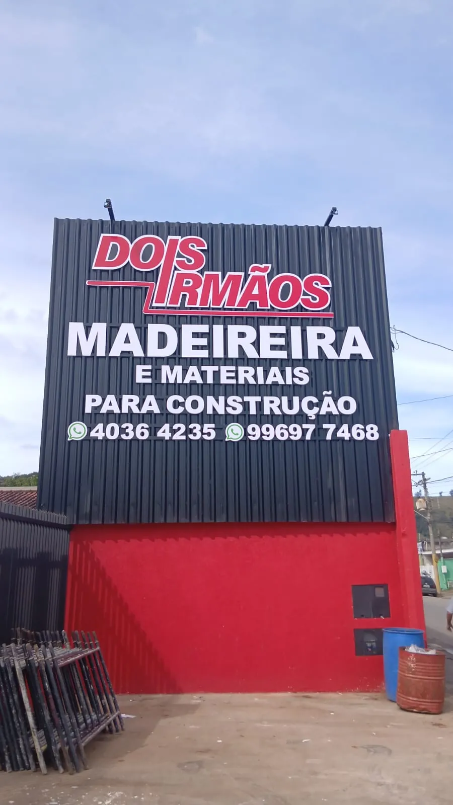Fachada da Dois Irmãos Madeireira com letreiro em grande formato sobre chapa metálica preta